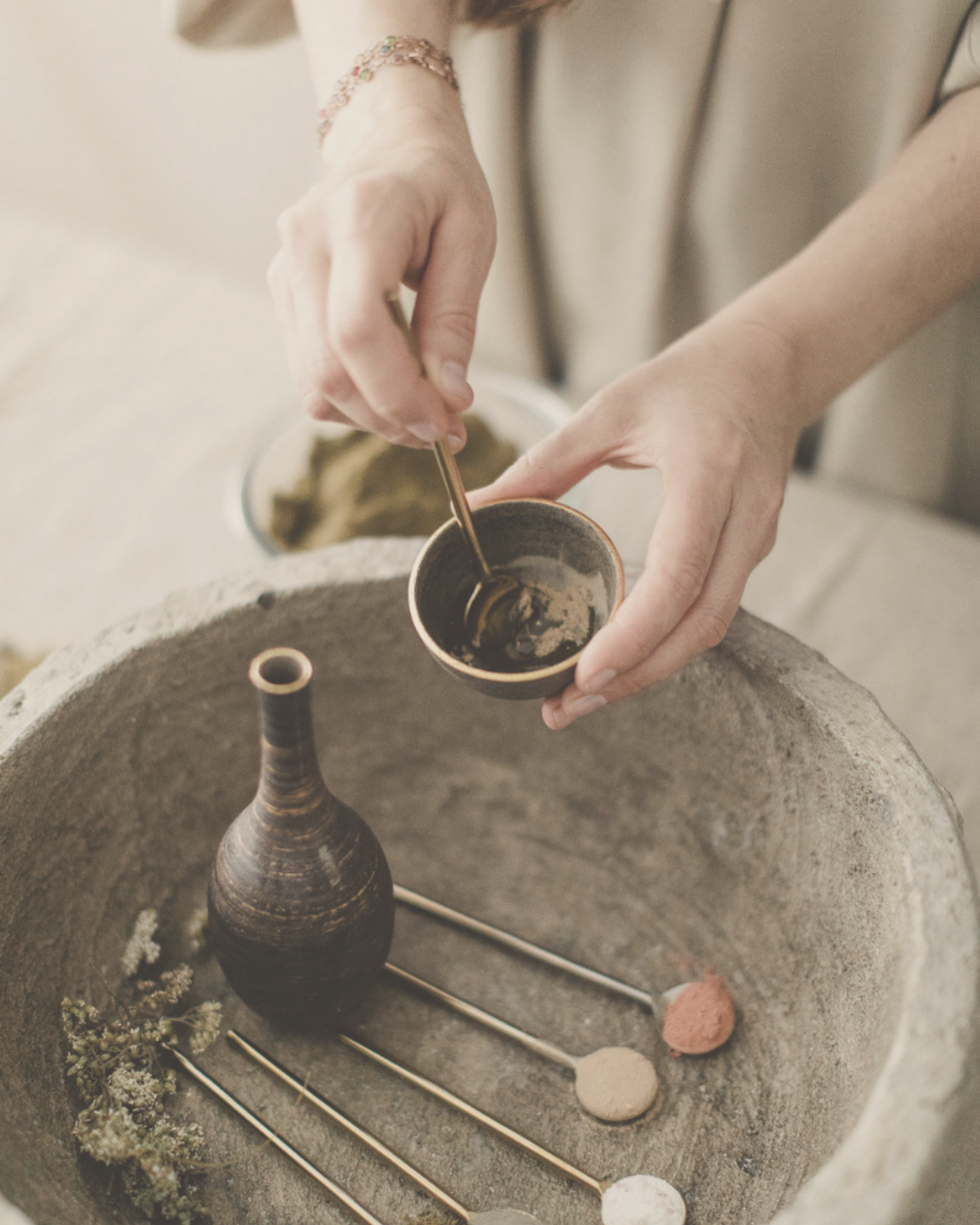 woman preparing organic, raw and ayurvedic skincare elixirs and powders