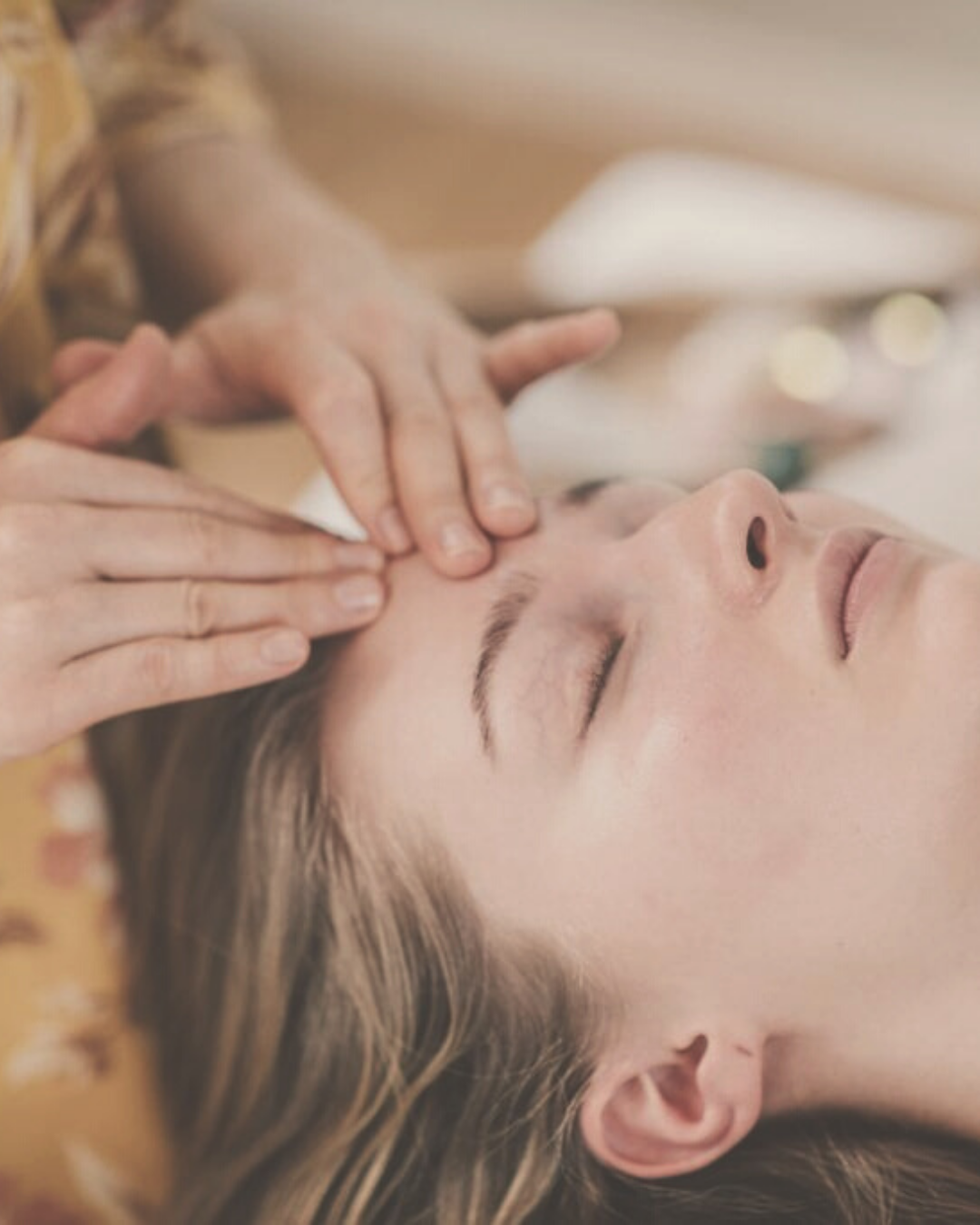 close-up of a woman's face receiving a rejuvenating facial marma therapy and energy healing