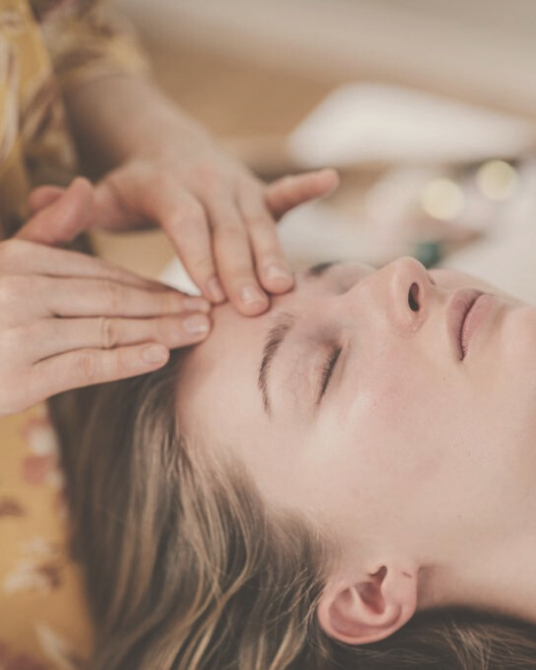 close-up of a woman's face receiving a rejuvenating facial marma therapy and energy healing 