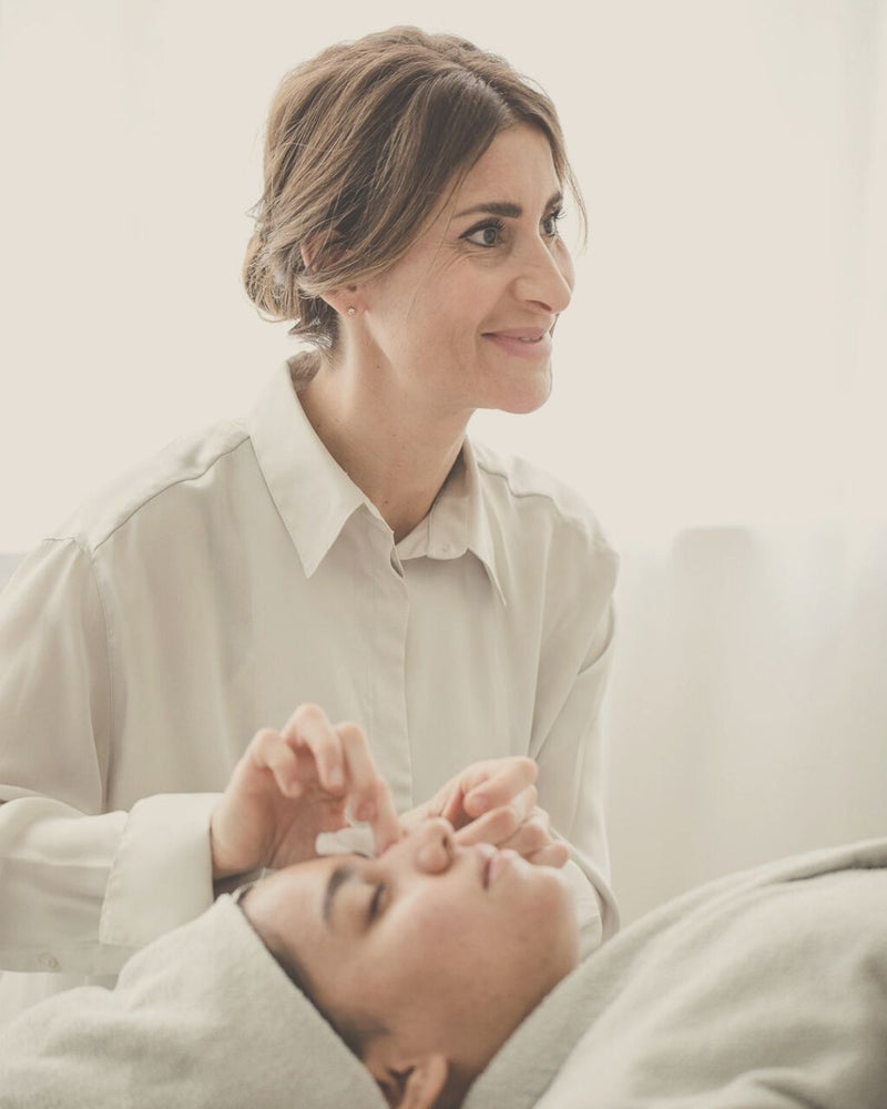 woman performing a holistic beauty treatment on another woman 