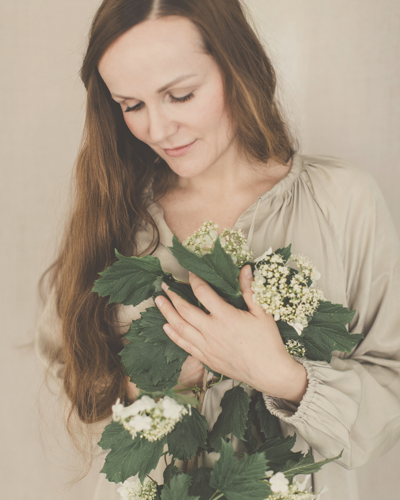 woman mindfully holding a bouquet of wild flowers close to her heart