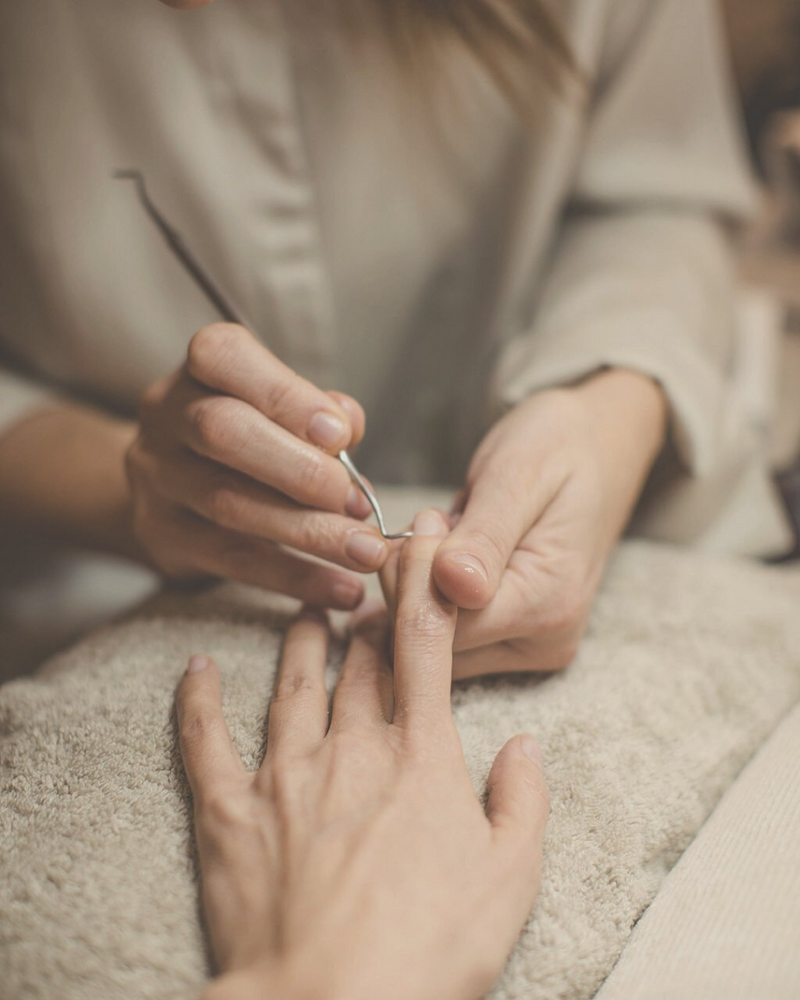 close-up of woman manicuring another woman's hand naturally and holistically 